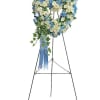Heart-shaped floral wreath on a standing easel with blue ribbon