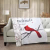 Quilted throw blanket with a red cardinal design draped over a sofa