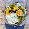 Bouquet of yellow roses, sunflower, and white hydrangea in a gold box