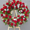 Red rose wreath on a wooden easel with silver foliage accents