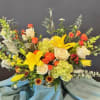 Bright yellow lilies take center stage in this airy garden-style flower arrangement
