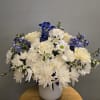White and blue flower arrangement in a white vase