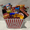 Popcorn bucket filled with soda bottles and assorted snack packs