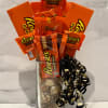 Reese's candy bouquet in a clear glass vase with black and gold ribbon curls