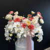 Large white orchid and pink rose arrangement in a white box with pink ribbon