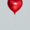 Red heart-shaped balloon with a thin string