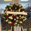 Heart-shaped wreath of red and white roses on a stand