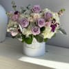 Lavender roses and white hydrangeas in a white hatbox