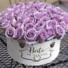 Lavender roses arranged in a round white hat box
