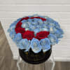 Round box of blue and red roses on a clear stand