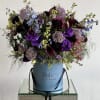 Purple and blue mixed bouquet in a blue hatbox with black ribbon handles