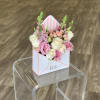 Pink and white roses in a striped gift box arrangement