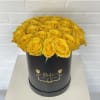 Yellow roses arranged in a black round box