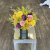 Bright bouquet of yellow, pink, and purple roses in a black box