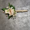 A boutonniere  featuring peach spray roses, peach ribbon, and peach rhinestones.

Depending