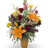 Mixed bouquet with orange lilies, burgundy roses, and yellow flowers in a vase