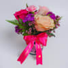 A joyful cluster of roses and carnations in soft peach, pale pink