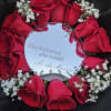 A bold circle of deep red roses arranged around a mirrored center