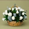 Pure white roses gathered low in a woven wicker basket create a