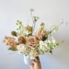 Pastel bouquet of roses and white blooms in a white vase