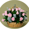 A dense cluster of pale pink roses arranged low in a woven