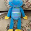 Bright blue cuddly frog plush with striped belly and yellow feet
