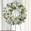White floral wreath on a black easel