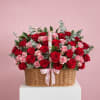 Basket arrangement of red and pink roses with a pink ribbon