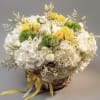 Basket arrangement of white and yellow flowers with green accents