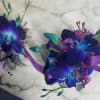 Two purple and blue orchid corsages with ribbon accents