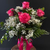 Pink roses with white baby's breath in a glass vase