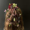Floral hairpiece with red, pink, and green blooms on long hair