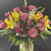 Pink roses and yellow lilies in a clear glass vase