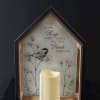 House-shaped memorial frame with a candle and bird illustration