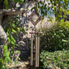 Decorative wind chime hanging from a tree in a garden