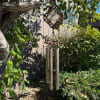 Decorative wind chime hanging from a tree branch outdoors