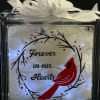 Illuminated glass block with red cardinal, memorial text, and white ribbon bow on top