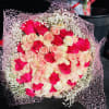 Bouquet of pink and cream roses wrapped in pink mesh