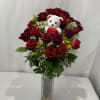 Red rose bouquet in a clear vase with a small teddy bear