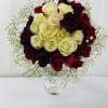 Bouquet of red and cream roses in a clear glass vase