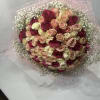 Large bouquet of pink, cream, and red roses wrapped in pale pink mesh