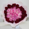 Bouquet of pink and red roses wrapped in pale pink paper