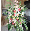 Large standing floral spray with pink, white, and peach blooms