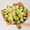 Bouquet of pink roses and pale lilies wrapped in brown paper
