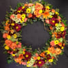 Heart-shaped floral wreath with orange, yellow, and burgundy blooms