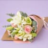 Bouquet of white lilies and pink roses wrapped in pastel paper