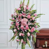 Pink funeral spray beside a casket