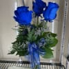 Bouquet of blue roses with a ribbon in a clear vase