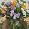 Mixed bouquet of pink, yellow, and white flowers in a glass vase