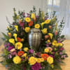 Colorful floral wreath around a silver urn centerpiece